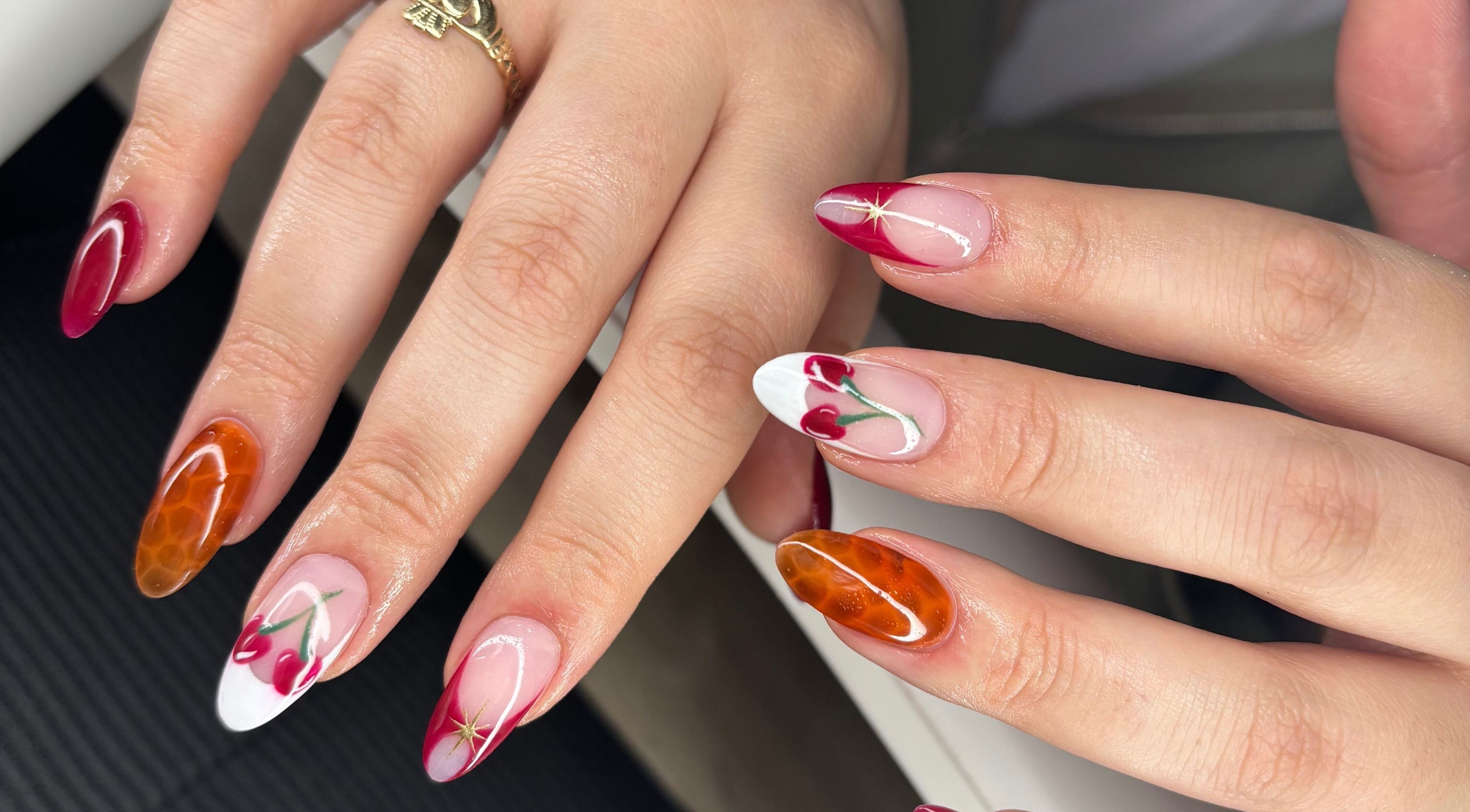 Elegant nail art design at The Lab ltd, London, England, GB with cherry and amber motifs.