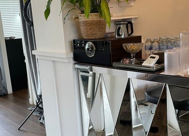 Stylish refreshment corner at Queen Lashes, Leicester, England, GB with water bottles and chic decor.
