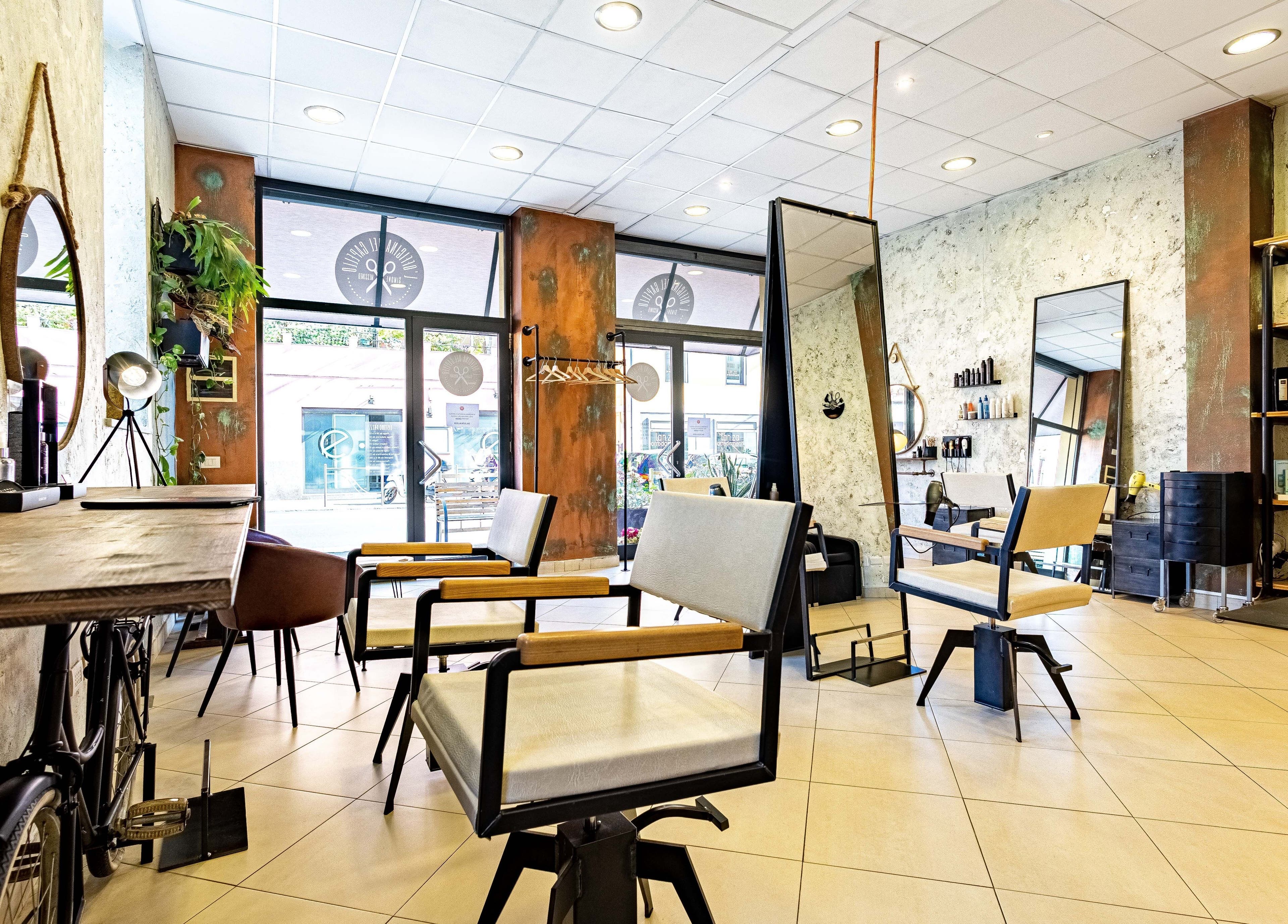 Interno moderno di L’officina Del Capello, Sanremo Liguria, IT, con eleganti sedie e specchi.