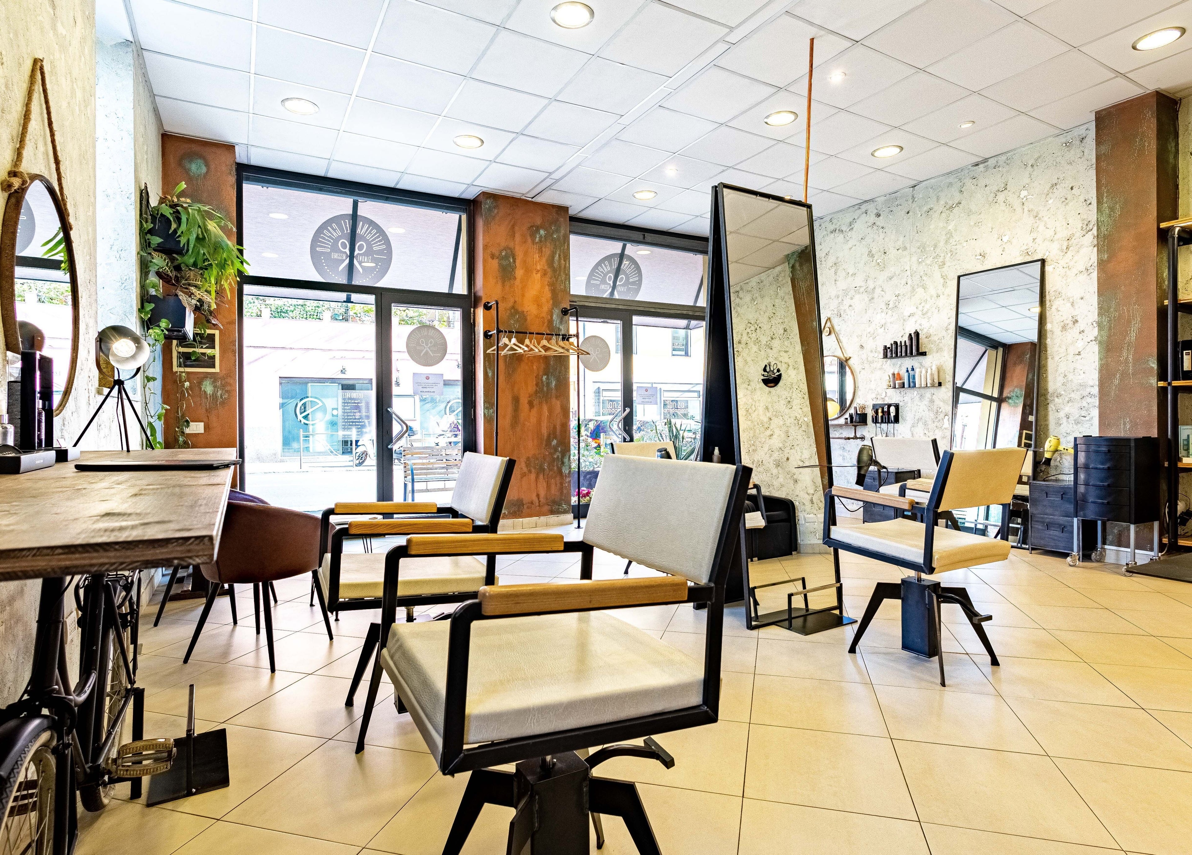 Interno moderno di L’officina Del Capello, Sanremo Liguria, IT, con eleganti sedie e specchi.