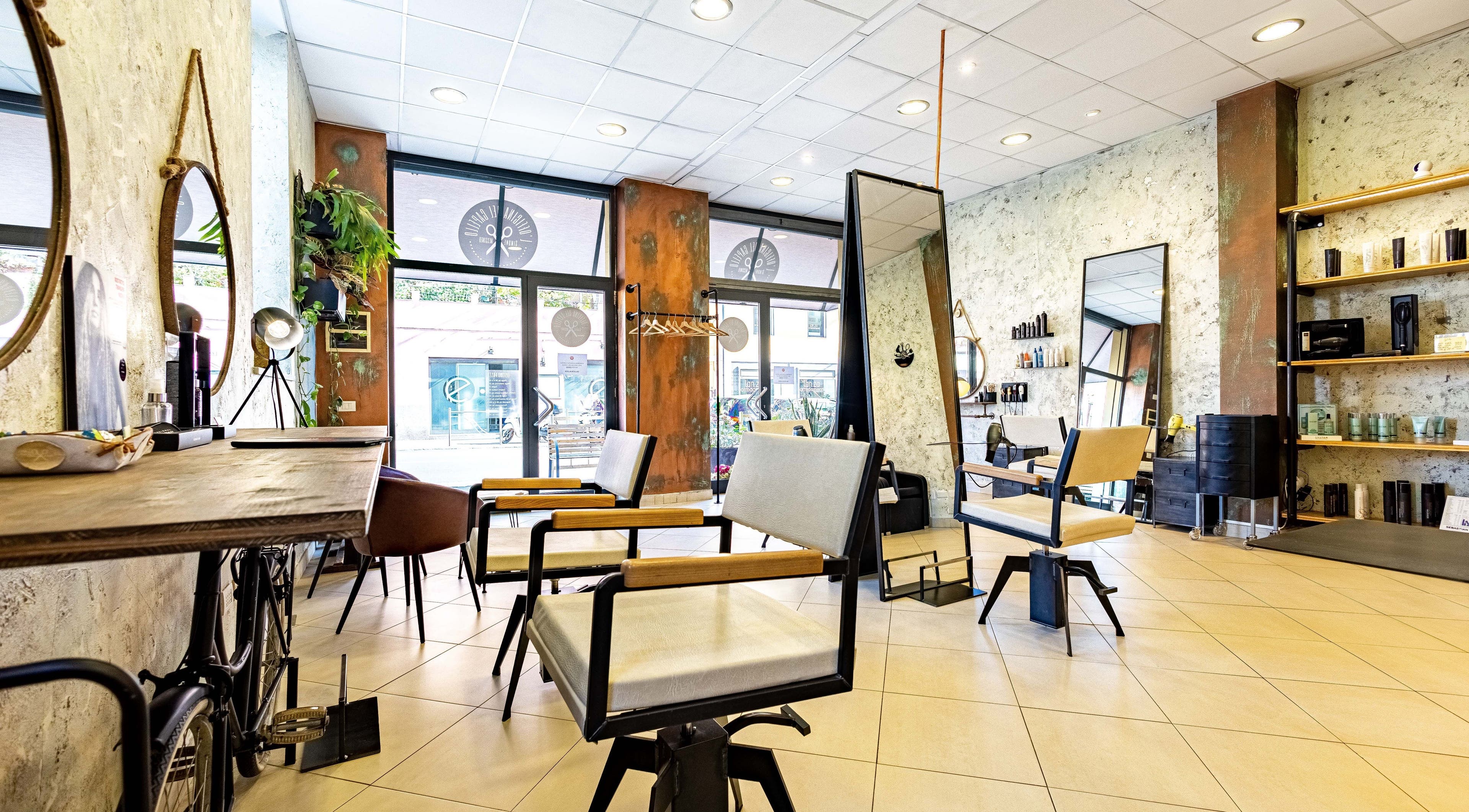 Interno moderno di L’officina Del Capello, Sanremo Liguria, IT, con eleganti sedie e specchi.