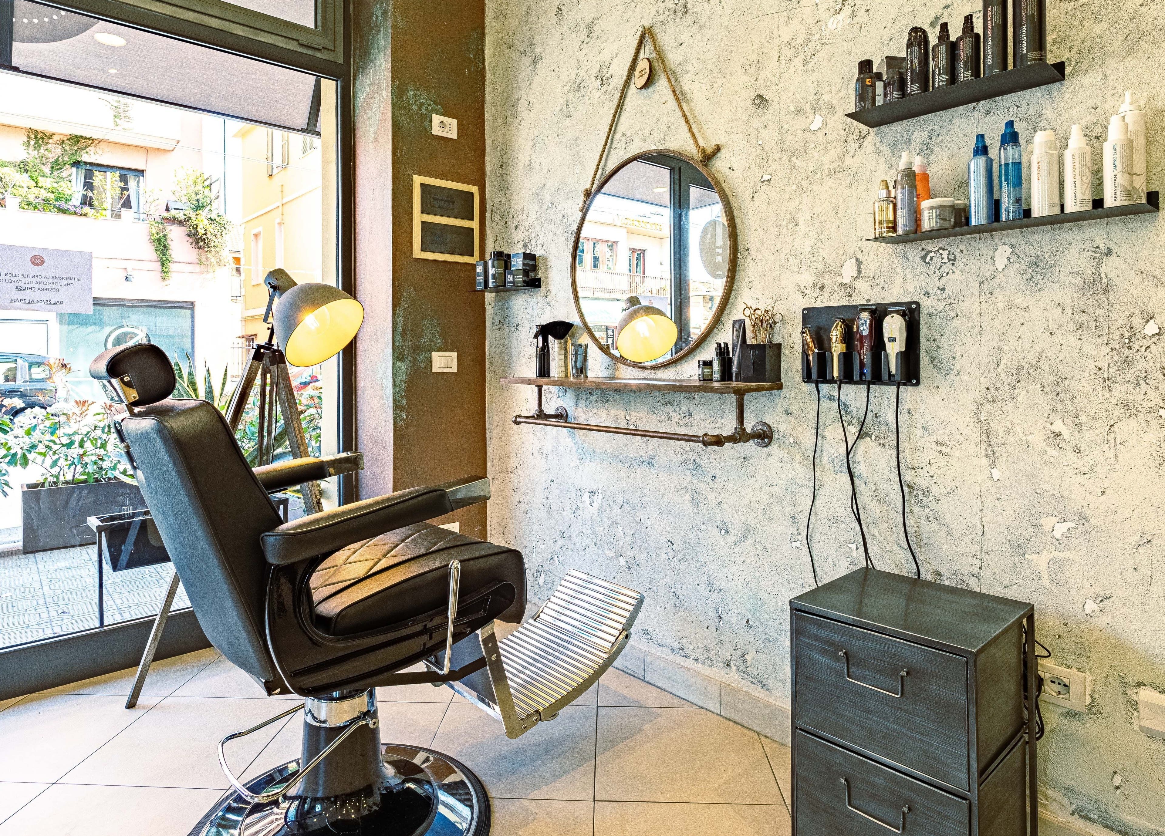 Interno di L’officina Del Capello a Sanremo, Liguria, IT con sedia da barbiere e accessori moderni.