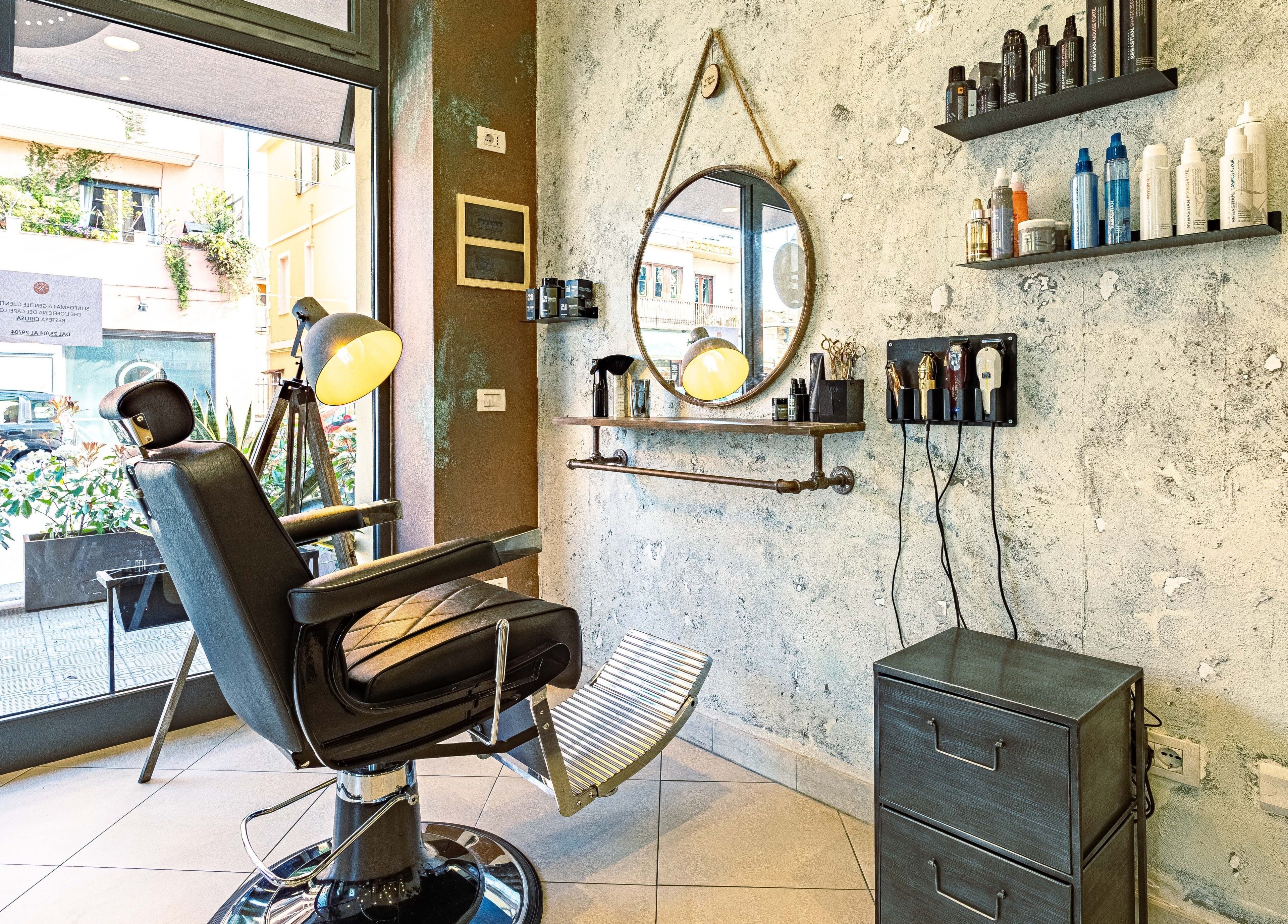 Interno di L’officina Del Capello a Sanremo, Liguria, IT con sedia da barbiere e accessori moderni.