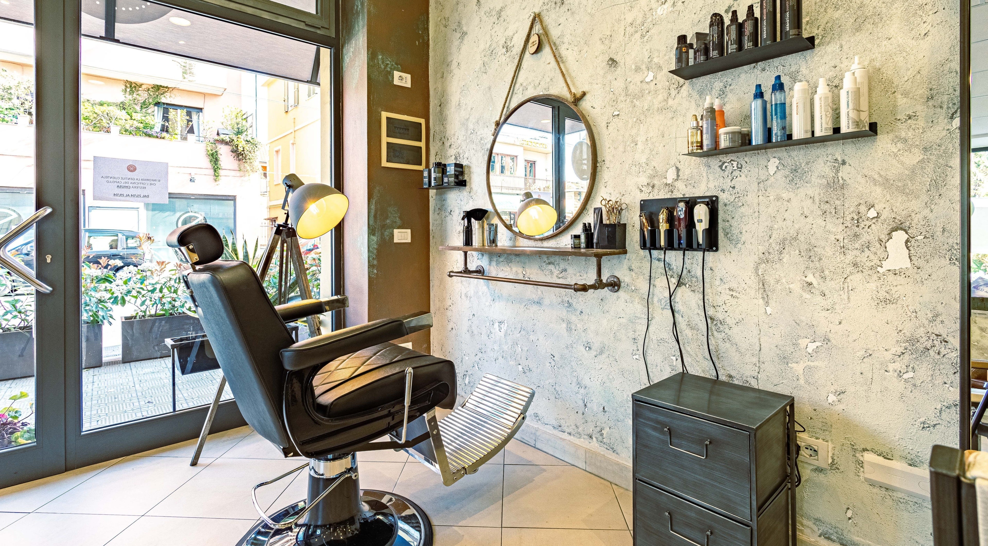 Interno di L’officina Del Capello a Sanremo, Liguria, IT con sedia da barbiere e accessori moderni.