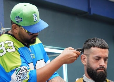 Barber skillfully trims hair at Polanco Barber in Humacao, PR, focusing on client satisfaction.