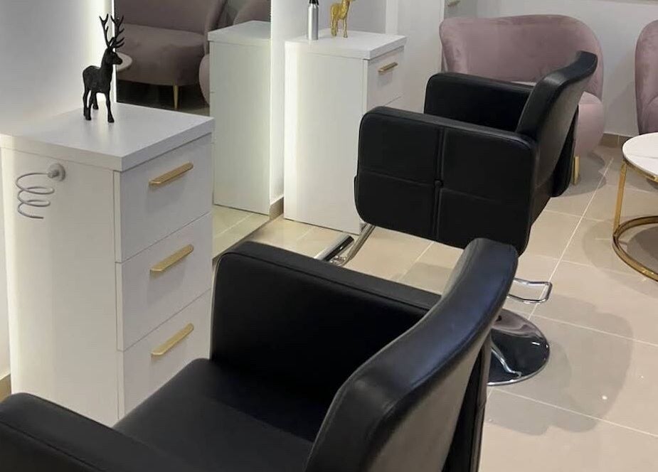 Chic salon interior at Bombshell Nail, Hair & Beauty Bar Malta in Tas-sliema, MT, featuring stylish black chairs.