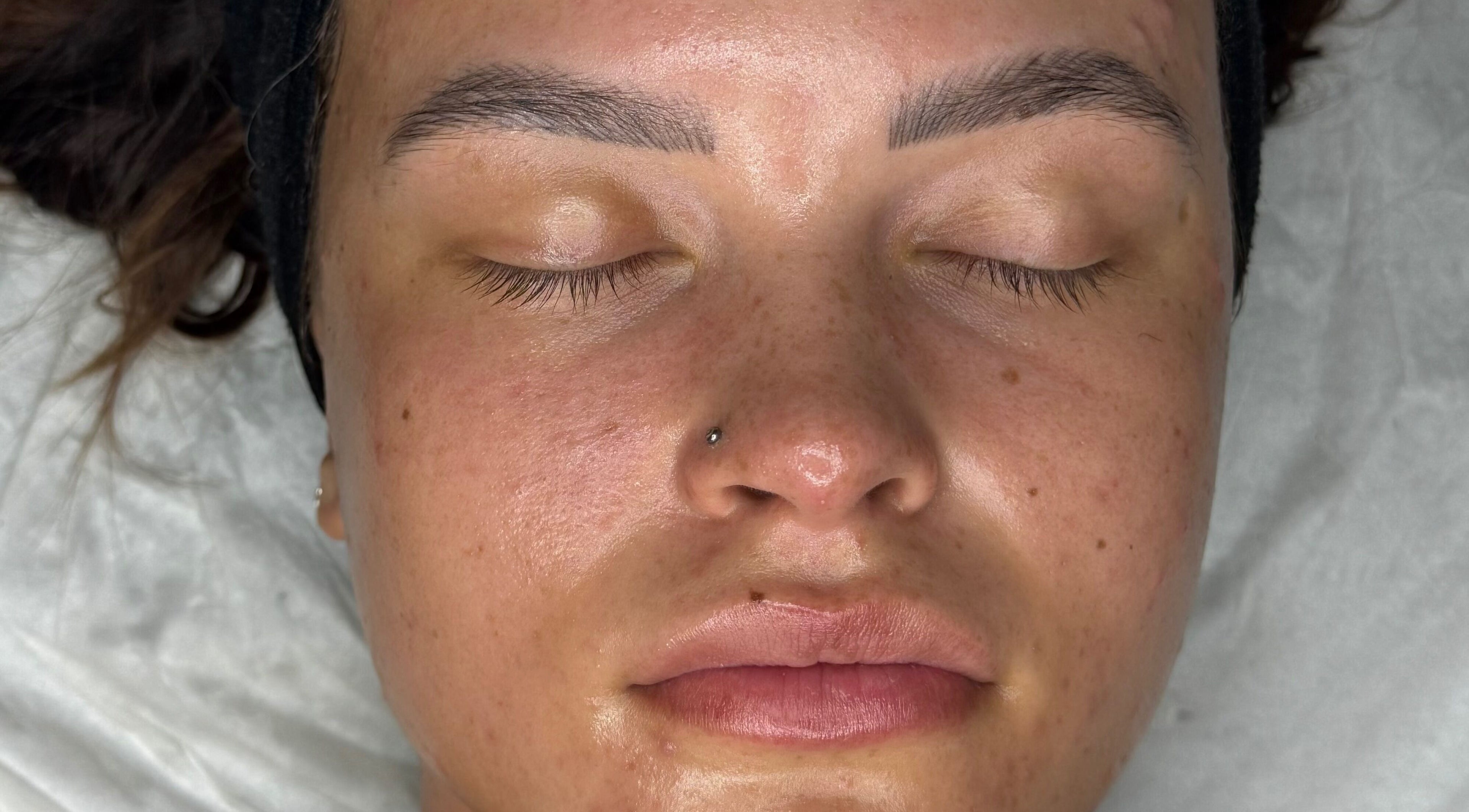 Close-up of a relaxed face post facial at Glossom Beauty, Motherwell, Scotland, GB. Smooth, rejuvenated skin.