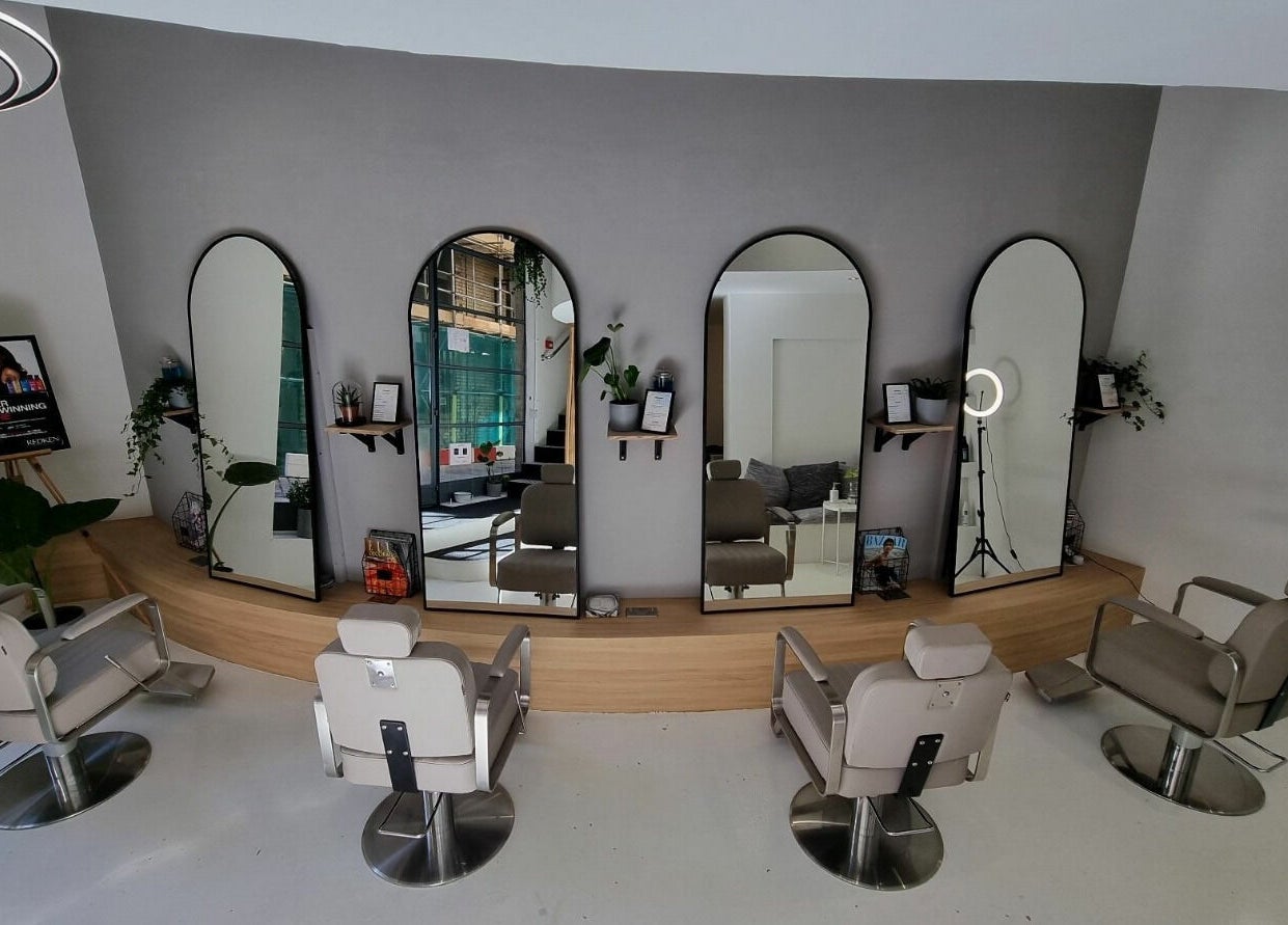 Modern interior of K&Co Hair Salon in London, England with stylish chairs and mirrors.