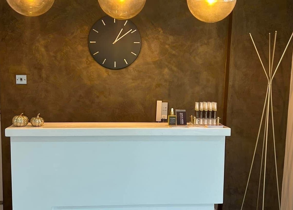 Elegant reception desk at Be Beautiful by Alex, Glenfield, England, GB with warm lighting and decor.