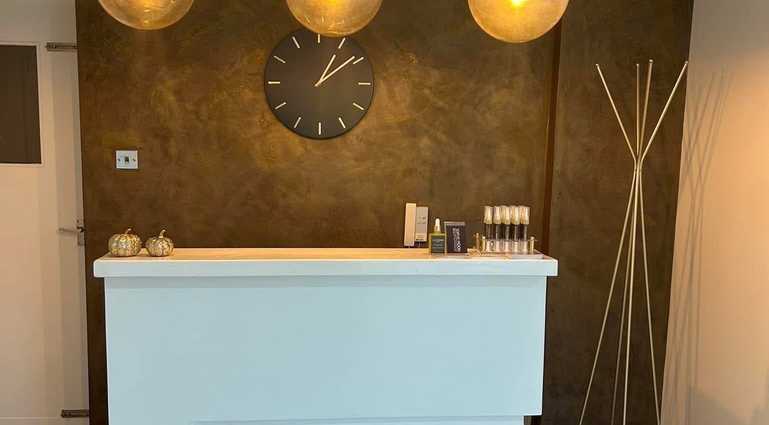 Elegant reception desk at Be Beautiful by Alex, Glenfield, England, GB with warm lighting and decor.