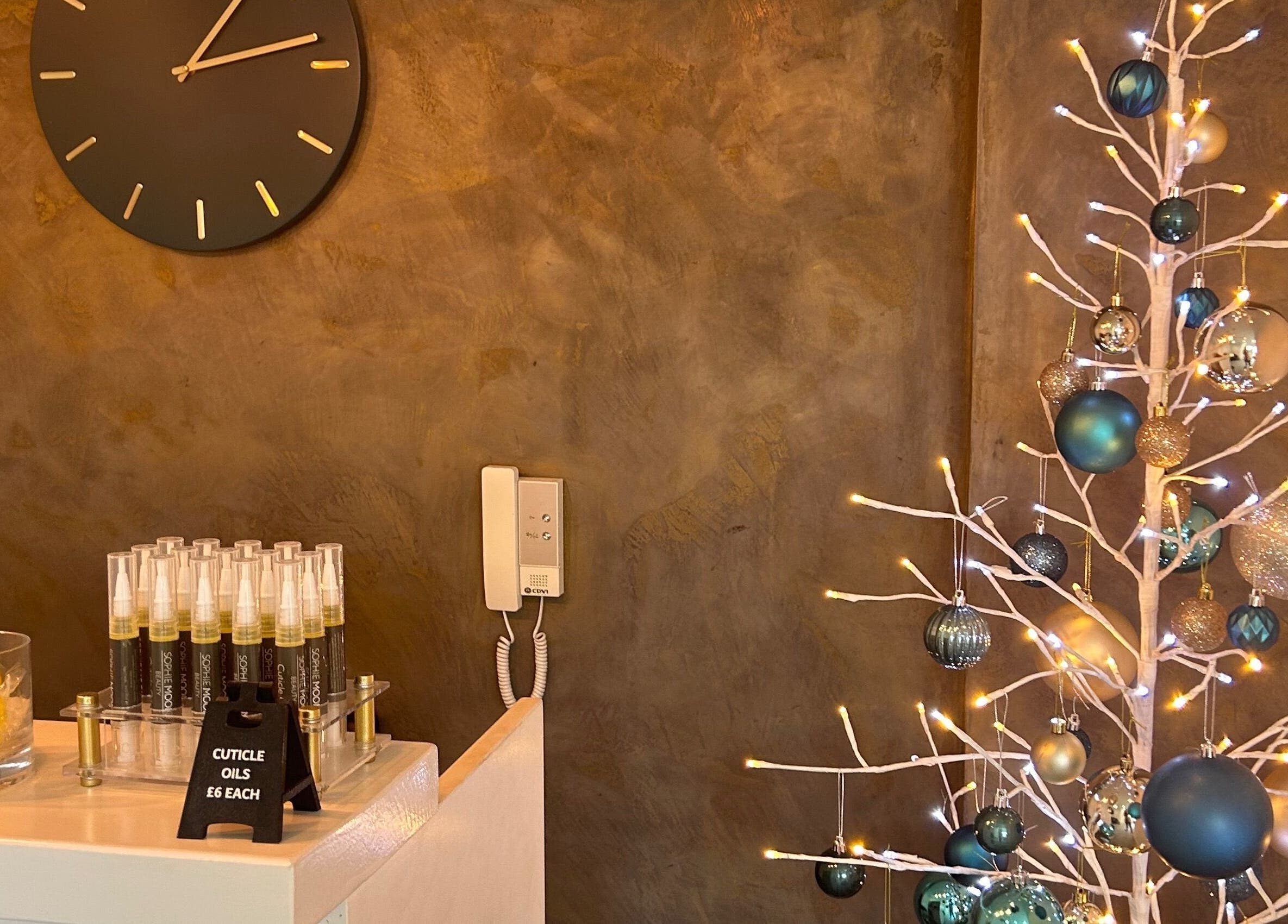 Stylish holiday decor at Be Beautiful by Alex, Glenfield, England, GB, with a lit tree and cuticle oils display.