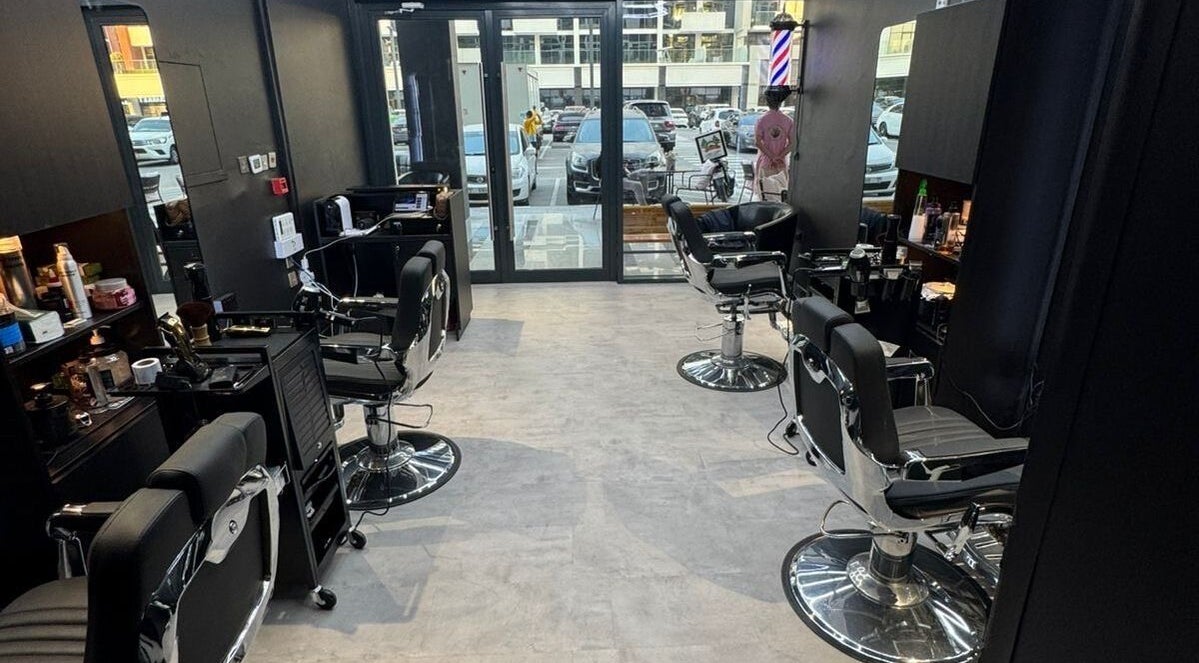 Modern interior of The Barber House - Azizi Riviera in Dubai, AE, showcasing sleek barber chairs and equipment.