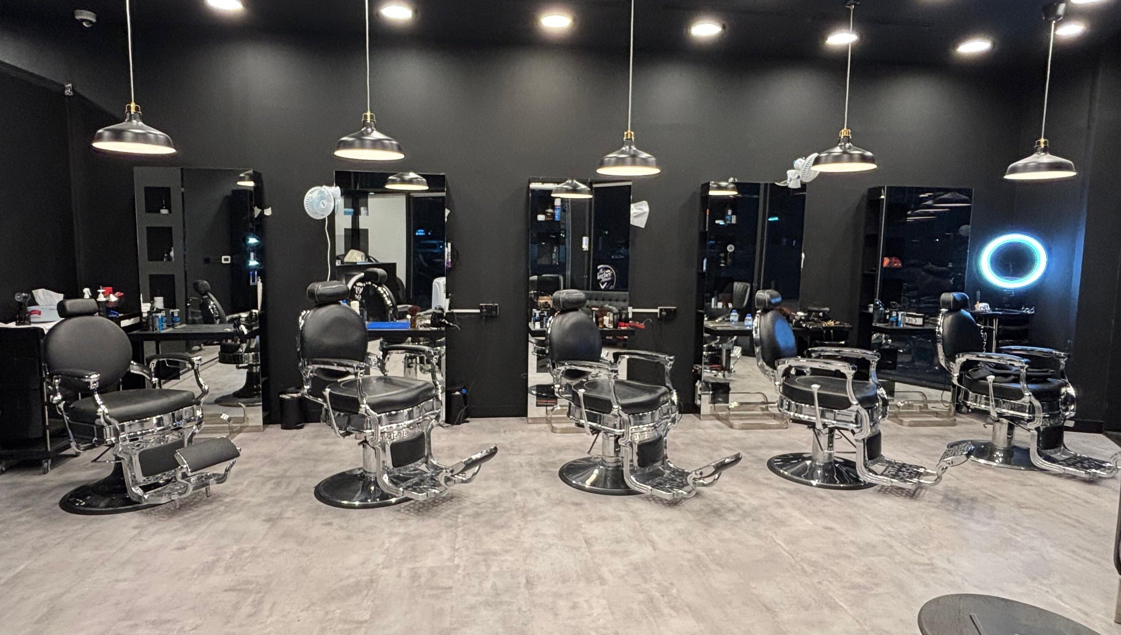 Modern barber chairs at The Barber House - JLT, Dubai, Dubai, AE with sleek black interiors.