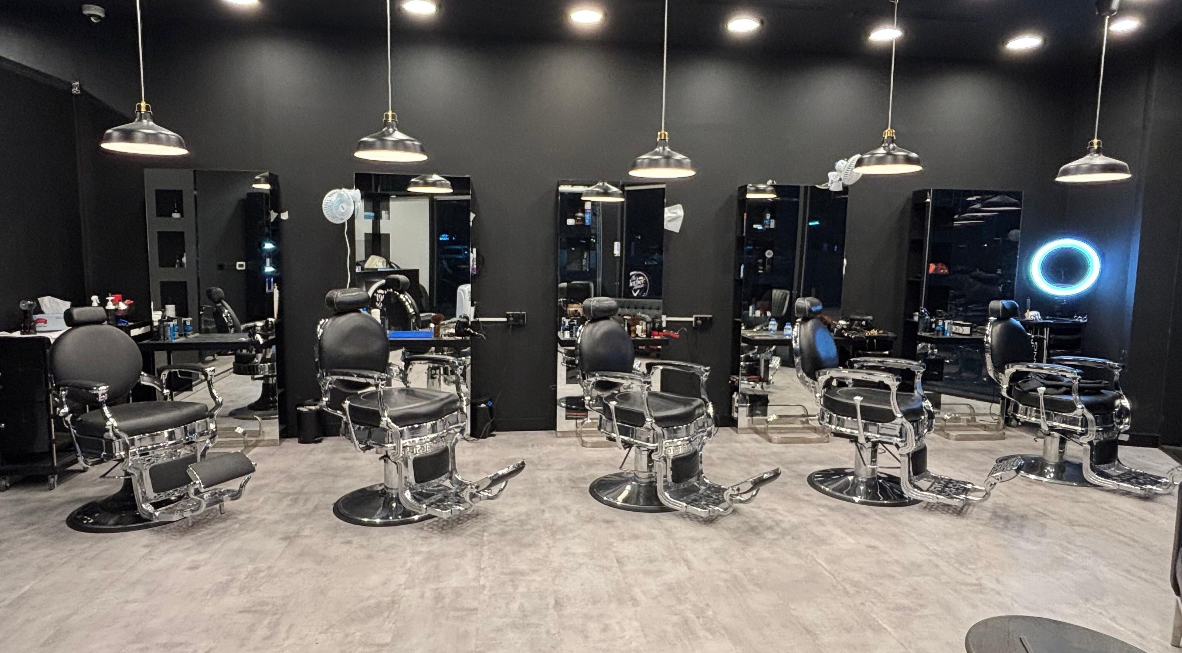 Modern barber chairs at The Barber House - JLT, Dubai, Dubai, AE with sleek black interiors.