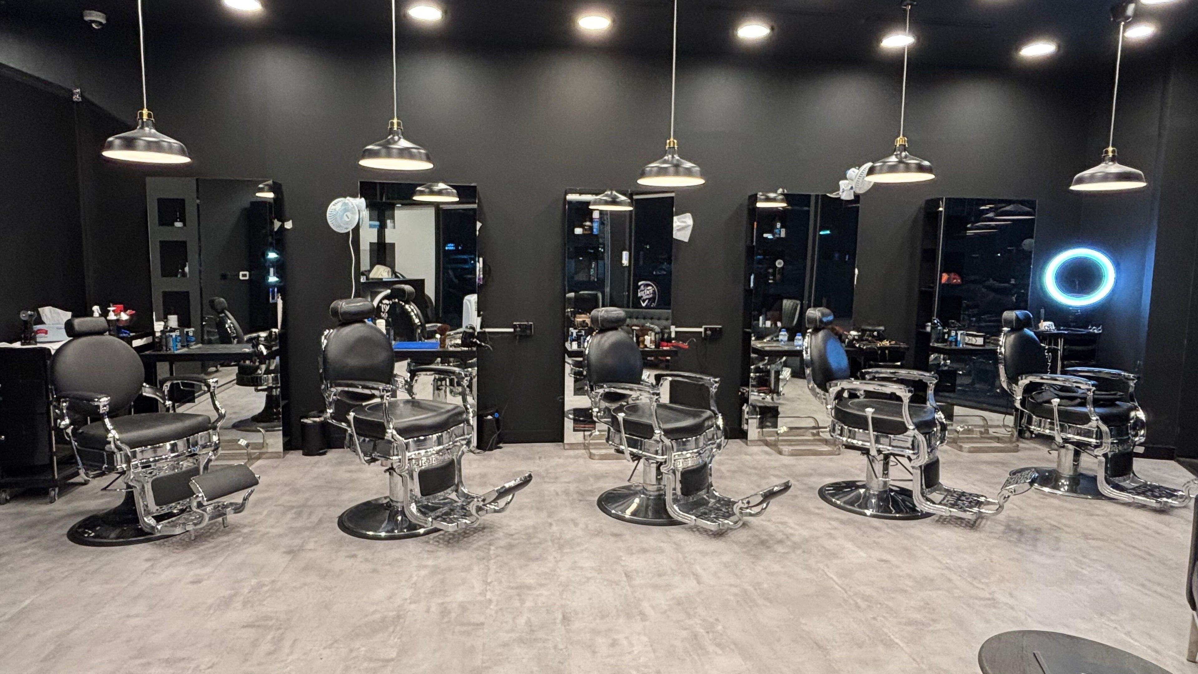 Modern barber chairs at The Barber House - JLT, Dubai, Dubai, AE with sleek black interiors.