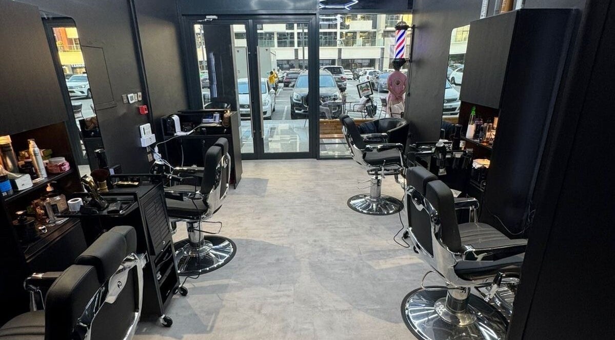 Modern barber shop interior at The Barber House - Azizi Riviera, Dubai, Dubai, AE with chic black chairs.