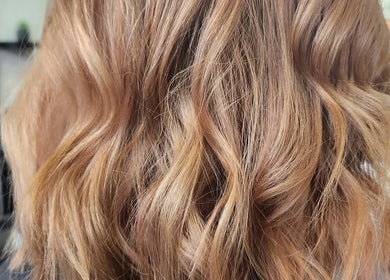 Golden blonde wavy hairstyle at Beauty Cutz, Telford, England, GB, showcasing soft curls and rich texture.