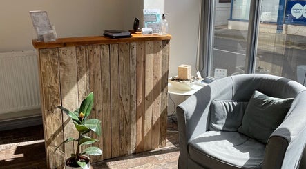 Welcoming reception area at In-Touch Therapies by Frances, Pontypool, Wales, GB, with wooden desk and plush chair.