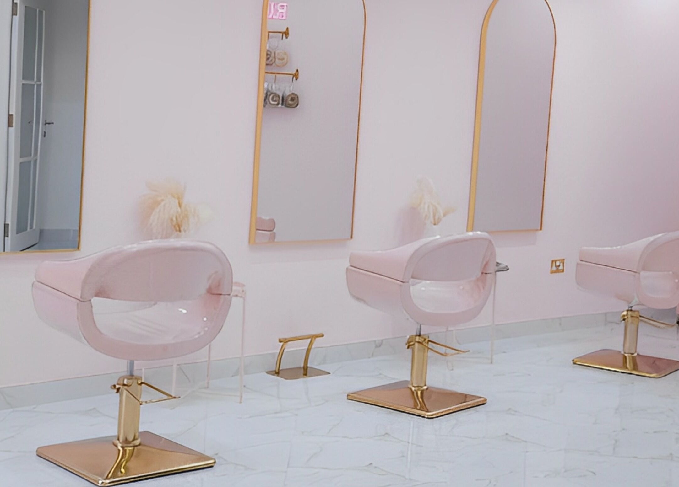 Chic styling area at The British Salon JLT, Dubai, Dubai, AE featuring stylish pink and gold salon chairs.