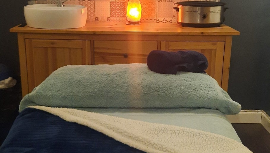 Cozy massage room at Renew Beauty Studio, Bangor, Northern Ireland, GB, featuring a plush table and ambient lighting.