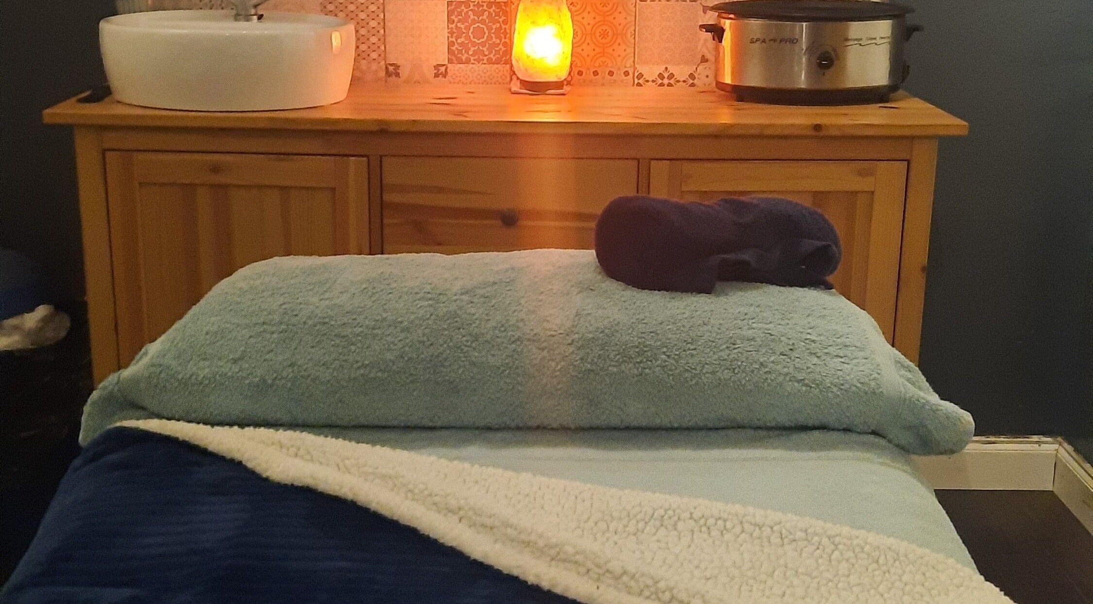 Cozy massage room at Renew Beauty Studio, Bangor, Northern Ireland, GB, featuring a plush table and ambient lighting.