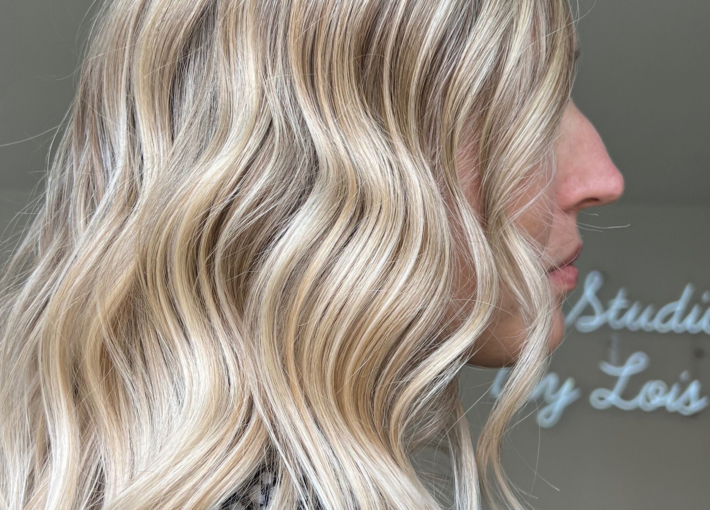 Elegant blonde waves hairstyle at The Studio by Lois in Shefford, England, GB with serene ambiance.