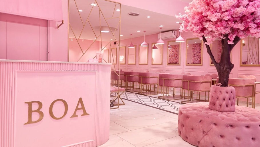 Elegant pink interior of BOA Beauty Bar Claremont, Cape Town, Western Cape, ZA featuring plush seating and cherry blossom decor.