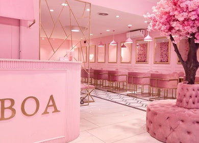 Elegant pink interior of BOA Beauty Bar Claremont, Cape Town, Western Cape, ZA featuring plush seating and cherry blossom decor.