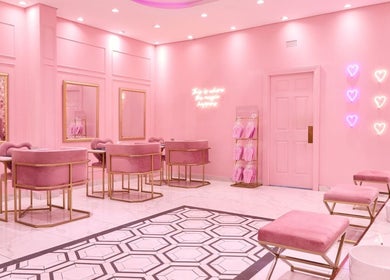Chic pink interior of BOA Beauty Bar Durbanville, Cape Town, Western Cape, ZA with elegant seating and neon lights.