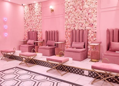 Cozy pink pedicure lounge at BOA Beauty Bar Durbanville, Cape Town, Western Cape, ZA with floral walls and neon lights.