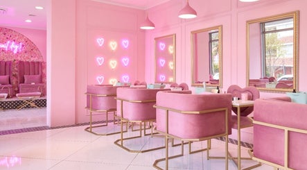 Chic pink interior of BOA Beauty Bar Sea Point, Cape Town, Western Cape, ZA with plush seating and heart neon lights.