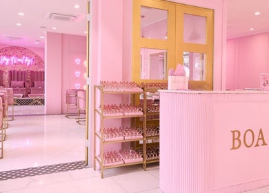 Inside BOA Beauty Bar Sea Point, Cape Town: chic pink decor with plush seating and stylish shelves.
