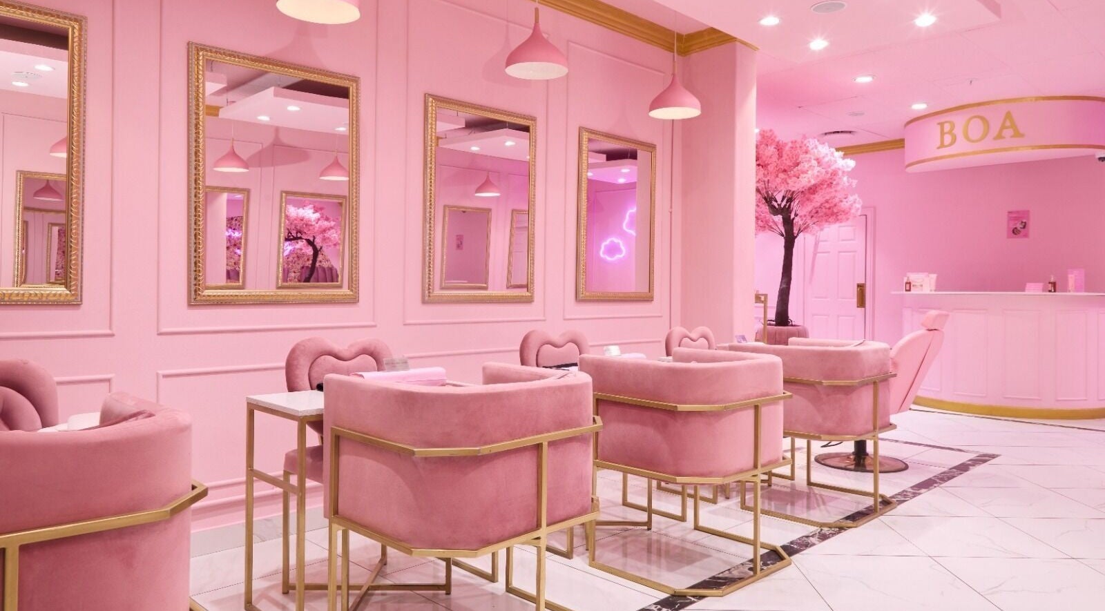 Chic interior of BOA Beauty Bar Rondebosch, Cape Town in pink decor with plush seating and mirrors.