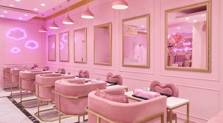 Chic pink interior of BOA Beauty Bar Rondebosch in Cape Town, Western Cape, ZA with neon clouds and plush seating.