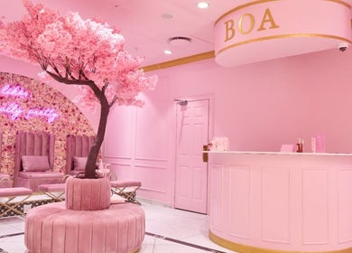 Chic pink interior of BOA Beauty Bar Rondebosch, Cape Town, Western Cape, ZA, featuring floral decor and seating.