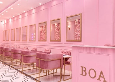 Chic pink interior of BOA Beauty Bar Plumstead in Cape Town, Western Cape, ZA with plush seating and elegant mirrors.