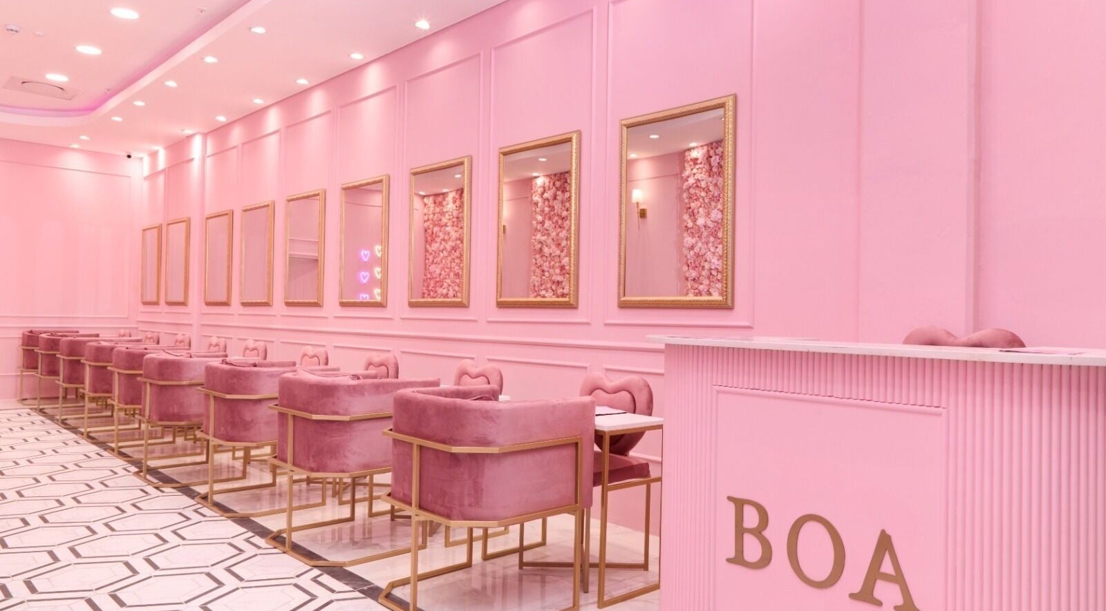 Chic pink interior of BOA Beauty Bar Plumstead in Cape Town, Western Cape, ZA with plush seating and elegant mirrors.