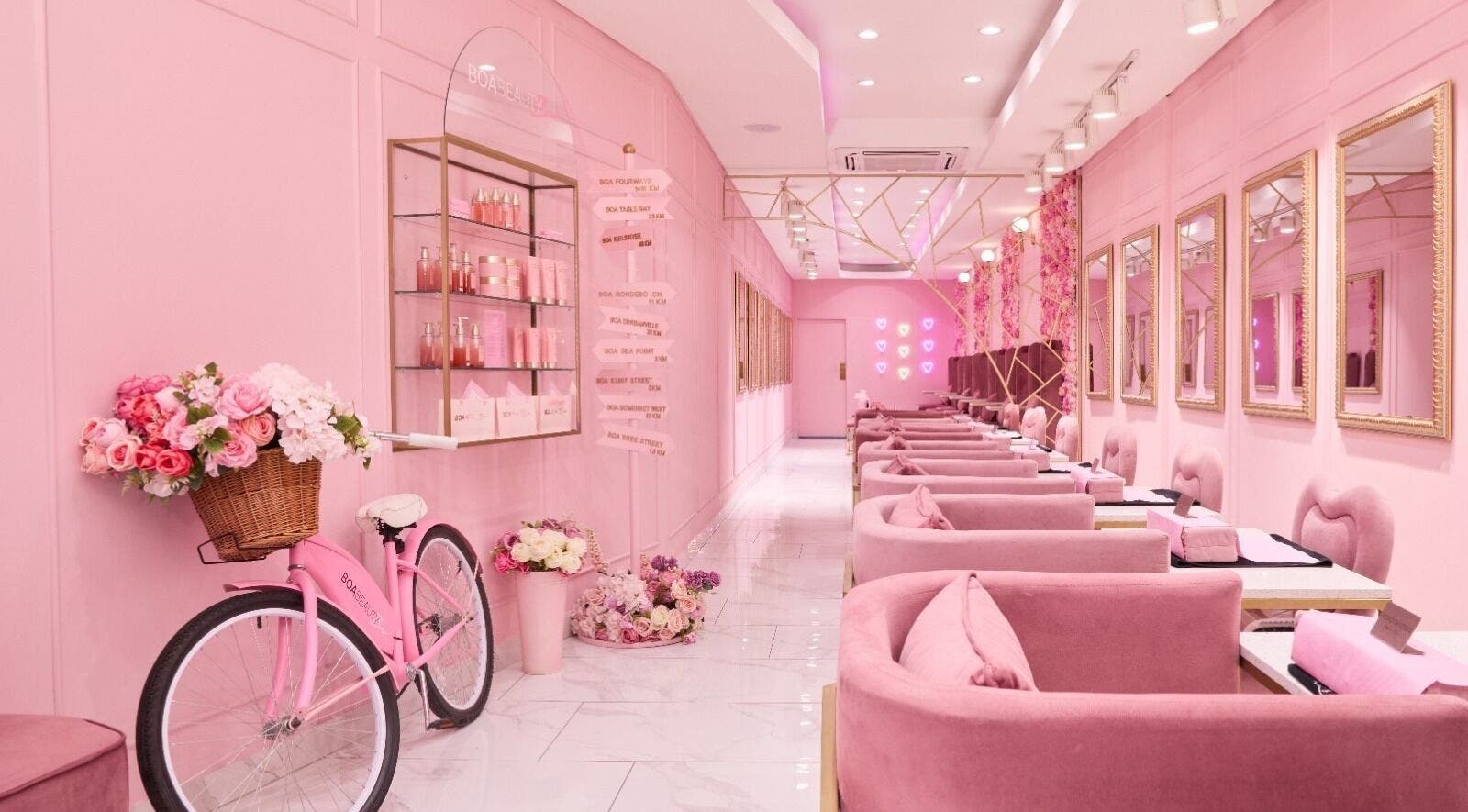 Elegant pink interior of BOA Beauty Bar Green Point in Cape Town, Western Cape, ZA with plush seating and floral decor.