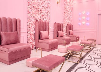 Elegant pink pedicure lounge at BOA Beauty Bar Sandown in Cape Town, Western Cape, ZA with velvet chairs and floral wall.