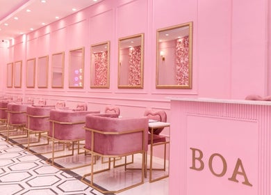 Chic pink interior of BOA Beauty Bar Sandown in Cape Town, Western Cape, ZA featuring plush seating and mirrors.