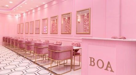 Chic pink interior of BOA Beauty Bar Sandown in Cape Town, Western Cape, ZA featuring plush seating and mirrors.