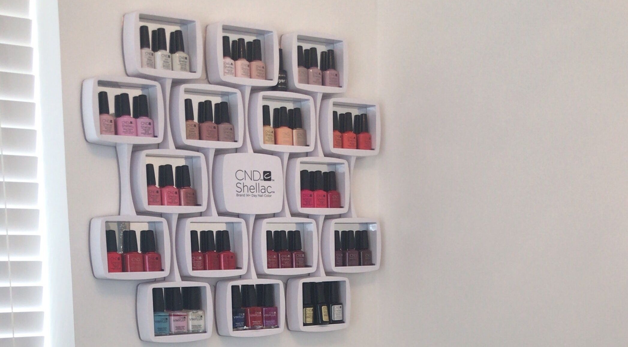 Chic nail polish rack at Pristine Beauty By Jodie in Poole, England, GB showcasing diverse colors.