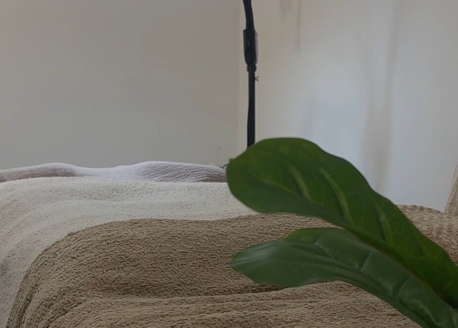Serene spa room at H L Beauty, Leeds, England, GB, featuring a cozy treatment bed and calming decor.