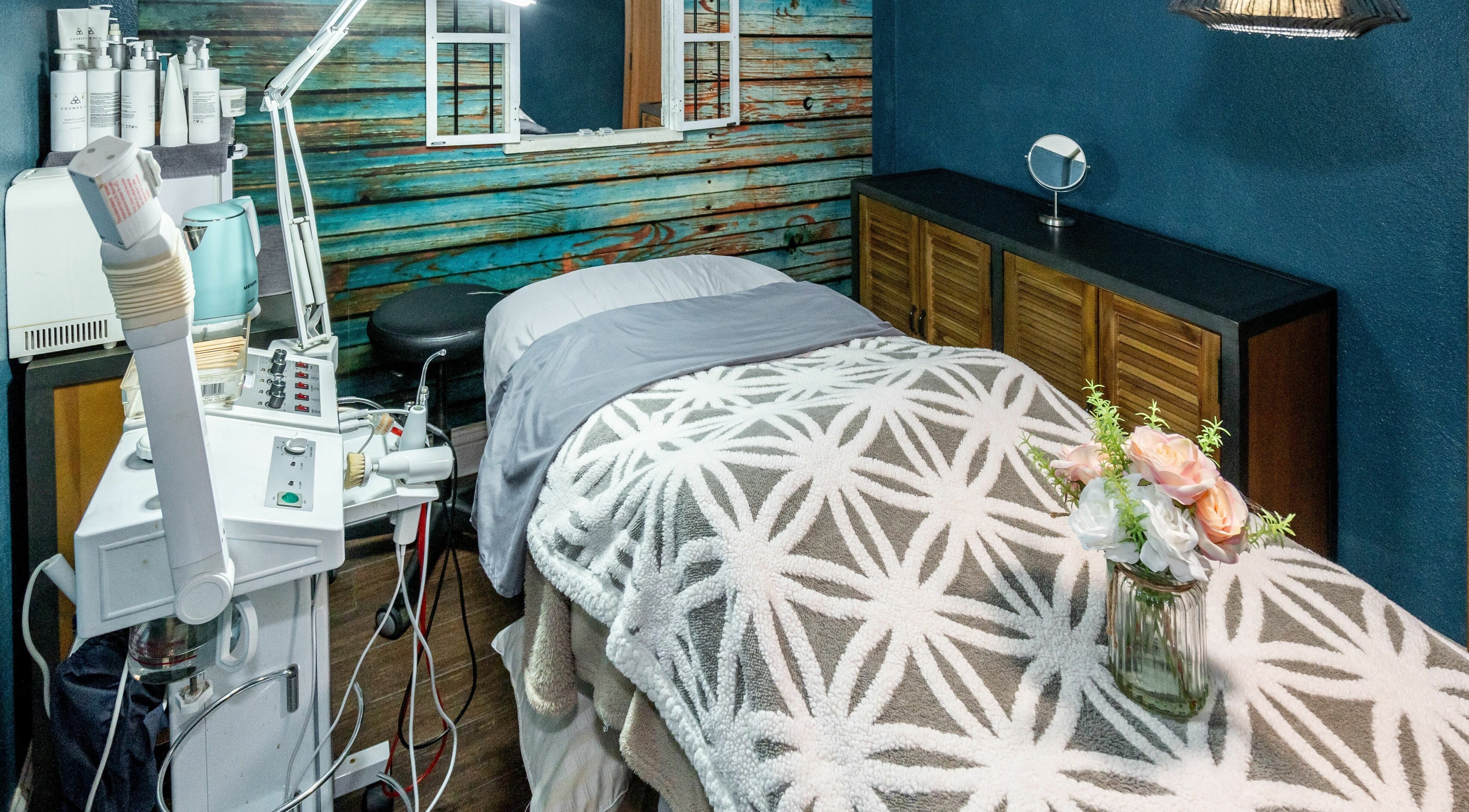 Relaxing treatment room at Bare Beauty Lounge, San Francisco, California, US with a cozy bed and spa equipment.