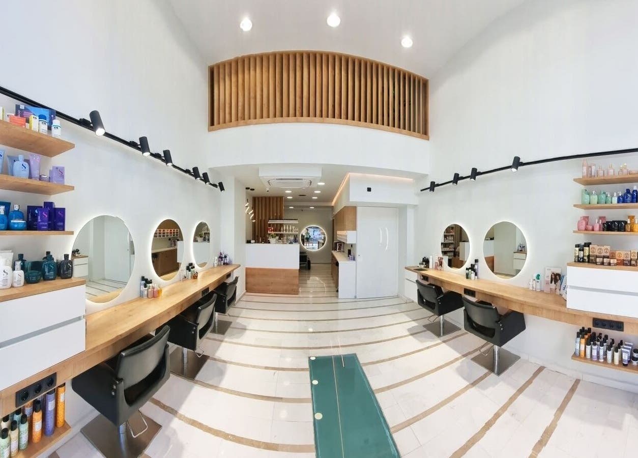 Σύγχρονο εσωτερικό κομμωτηρίου Strataras στο Ηράκλειο GR με καθρέπτες και προϊόντα ομορφιάς σε ράφια.