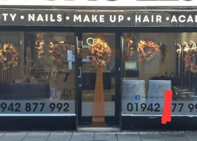 Front view of Beauty by Anita in Tyldesley, England, GB, adorned with autumn wreaths.
