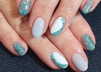 Blue and white glitter nail art at Beauty by Anita, Tyldesley, England, GB.