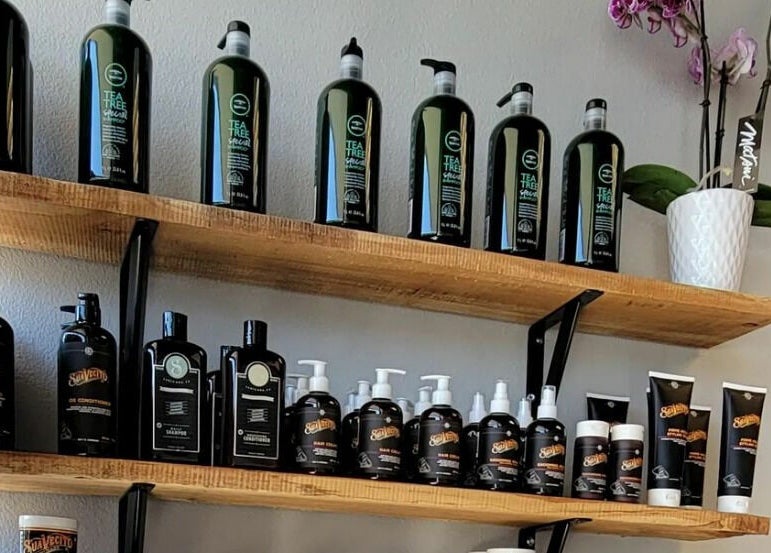 Product display at Royalz Barbers, Oregon City, Oregon, US, featuring hair care items and a potted orchid.