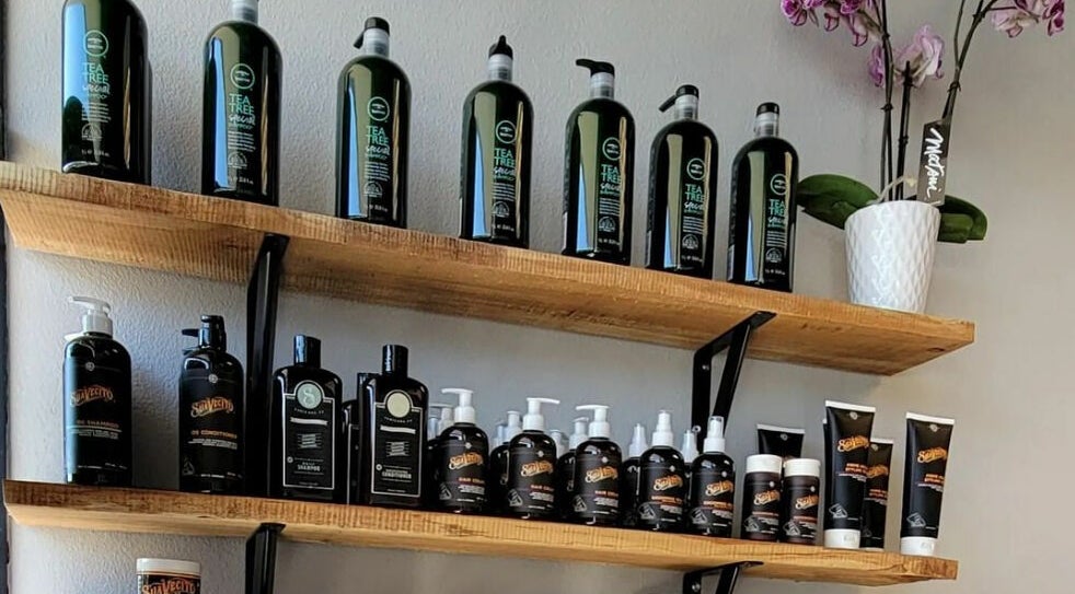 Product display at Royalz Barbers, Oregon City, Oregon, US, featuring hair care items and a potted orchid.