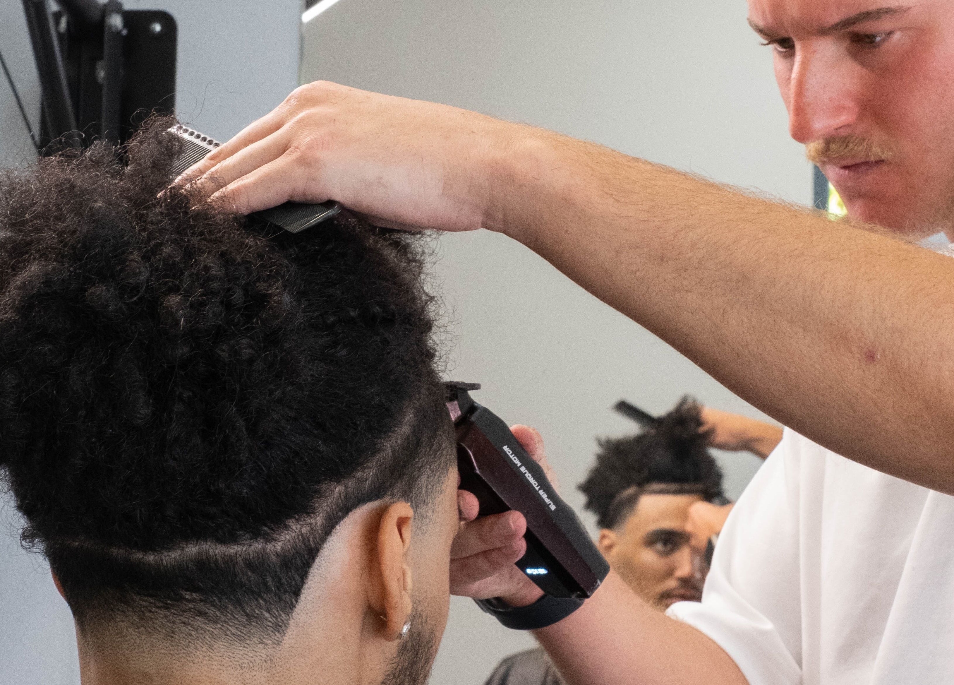 Expert barber at FLETCHCUTZ in Woodvale, Western Australia, AU, intricately styles client's hair.